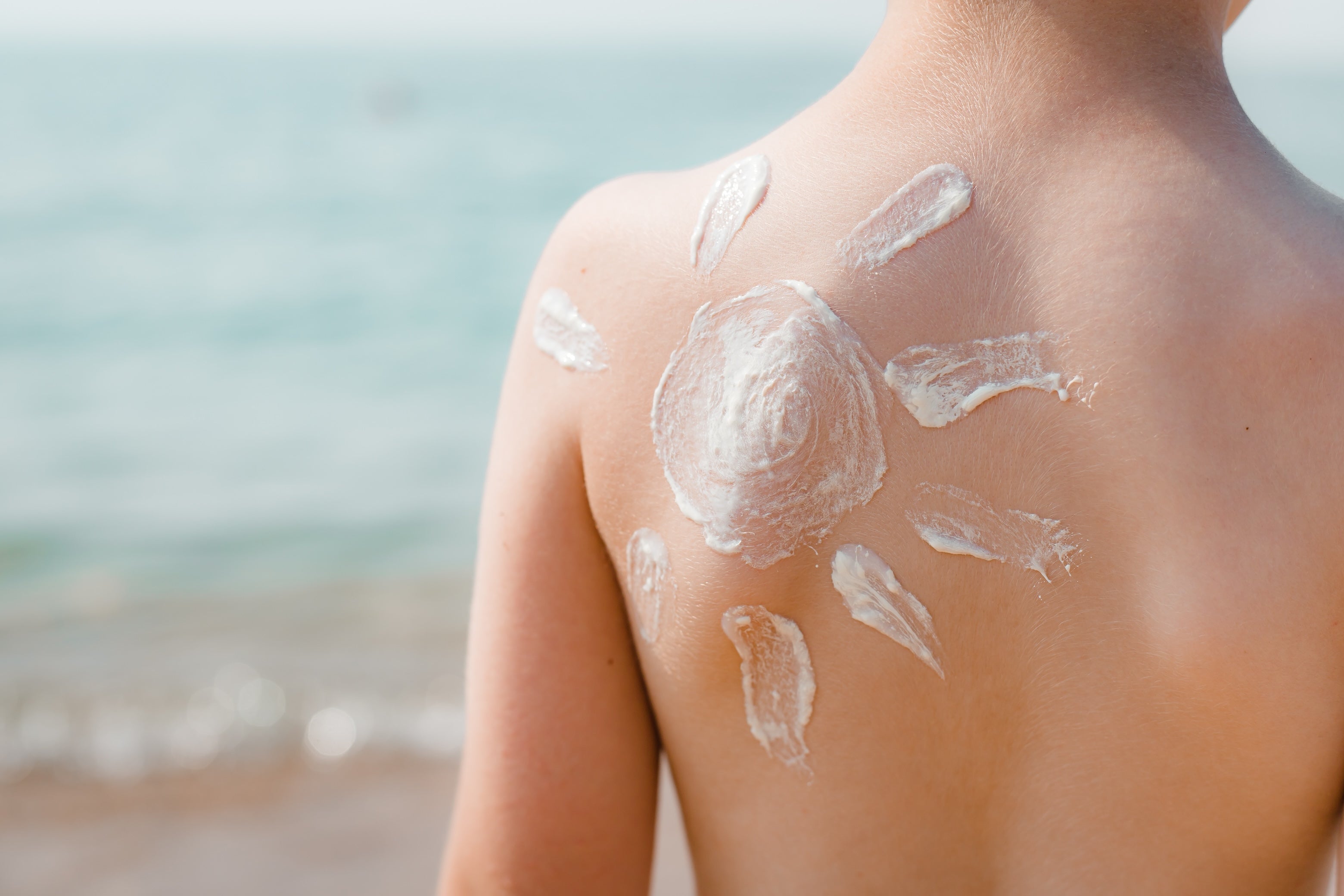 sunscreen in the shape of a sun on a childs back. Zinc Oxide Non-Nano Sunscreen Concept